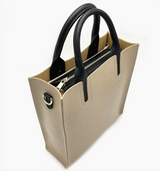 Beige handbag with black handles and zippers on a white background