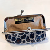 A small leather coin purse with a leopard print pattern on the bottom half, a beige interior, and a silver-tone metal frame with a clasp. A black label on the inside reads 'GENUINE LEATHER MADE IN ITALY'.