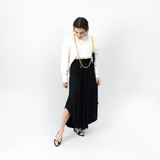 Lux bag worn on shoulder with cross body chain hanging like a necklace_full body view