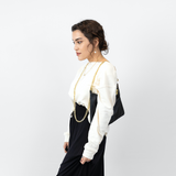 Lux bag worn on shoulder with cross body chain hanging like a necklace_side view