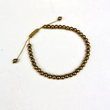 Gold beaded bracelet on a white background