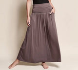 Person wearing a long brown skirt on a beige background