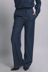 Denim pants worn by a person on a gray background