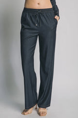 Dark blue pants worn by a person on a gray background