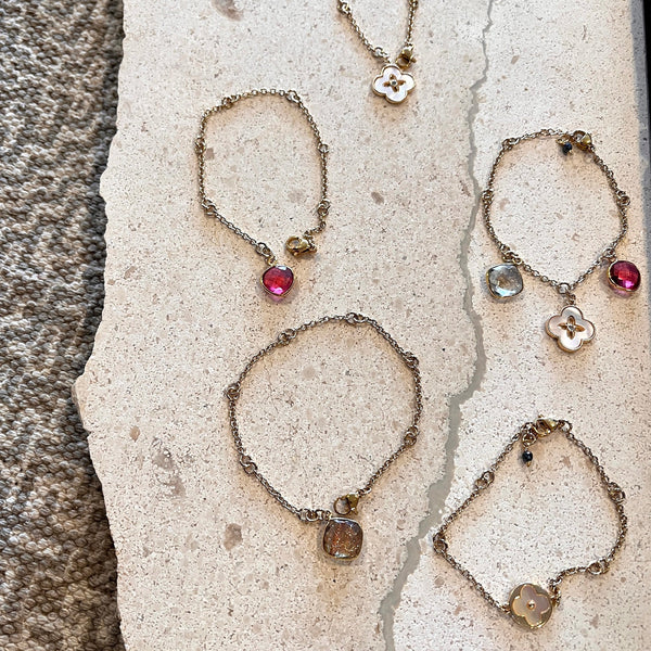 The collection of GF Double ring Bracelet with Mother of Pearl Clovers with center CZ, Tourmaline Quartz Charms, and Copper Infused Quartz Charms