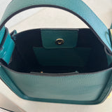 Close-up of a green handbag with a gold clasp on a white background