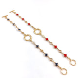 2 Gold bracelets with clover-shaped links on a white background. One Navy and one red.