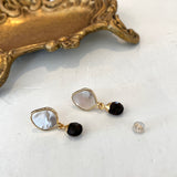 Pair of gold stud earrings with  mother of  pearl and smokey quartz on a white background