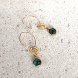gold filled raw emerlad and vermeil earrings on a white stone background