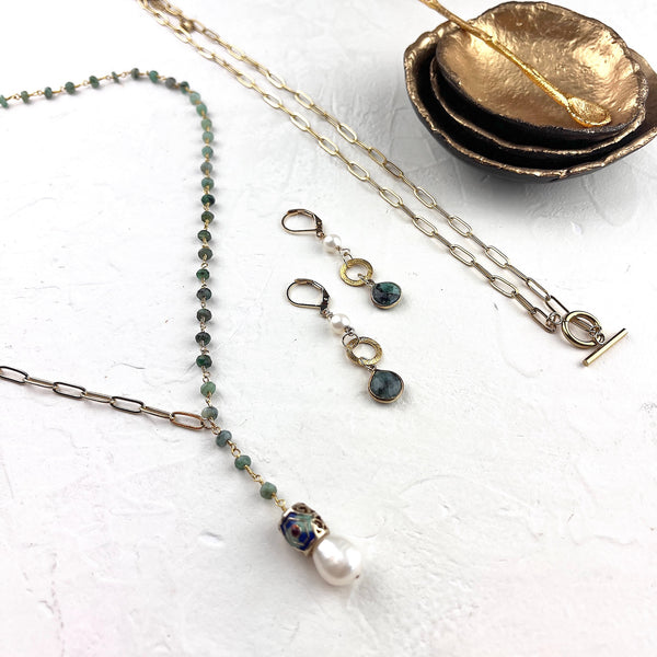 Jewelry set including necklace and earrings on a white surface