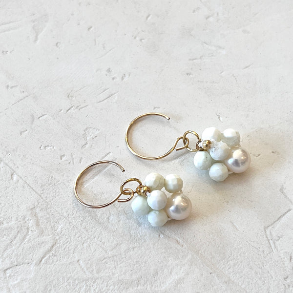 Pair of pearl earrings on a light gray textured background