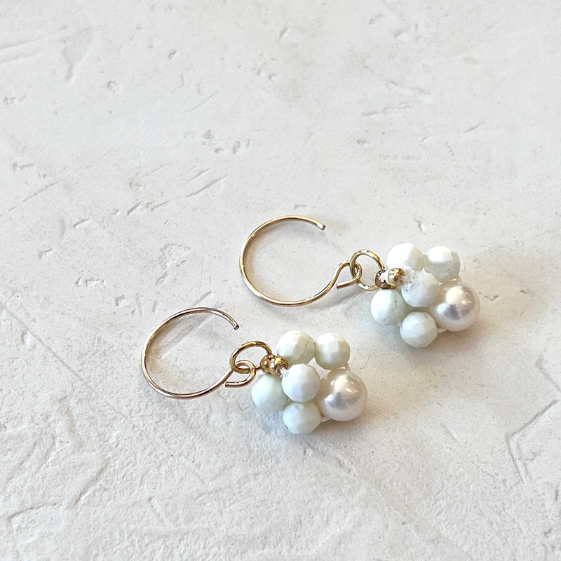 Pair of pearl earrings on a light gray textured background
