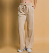 Beige sweatpants worn by a person on a beige background